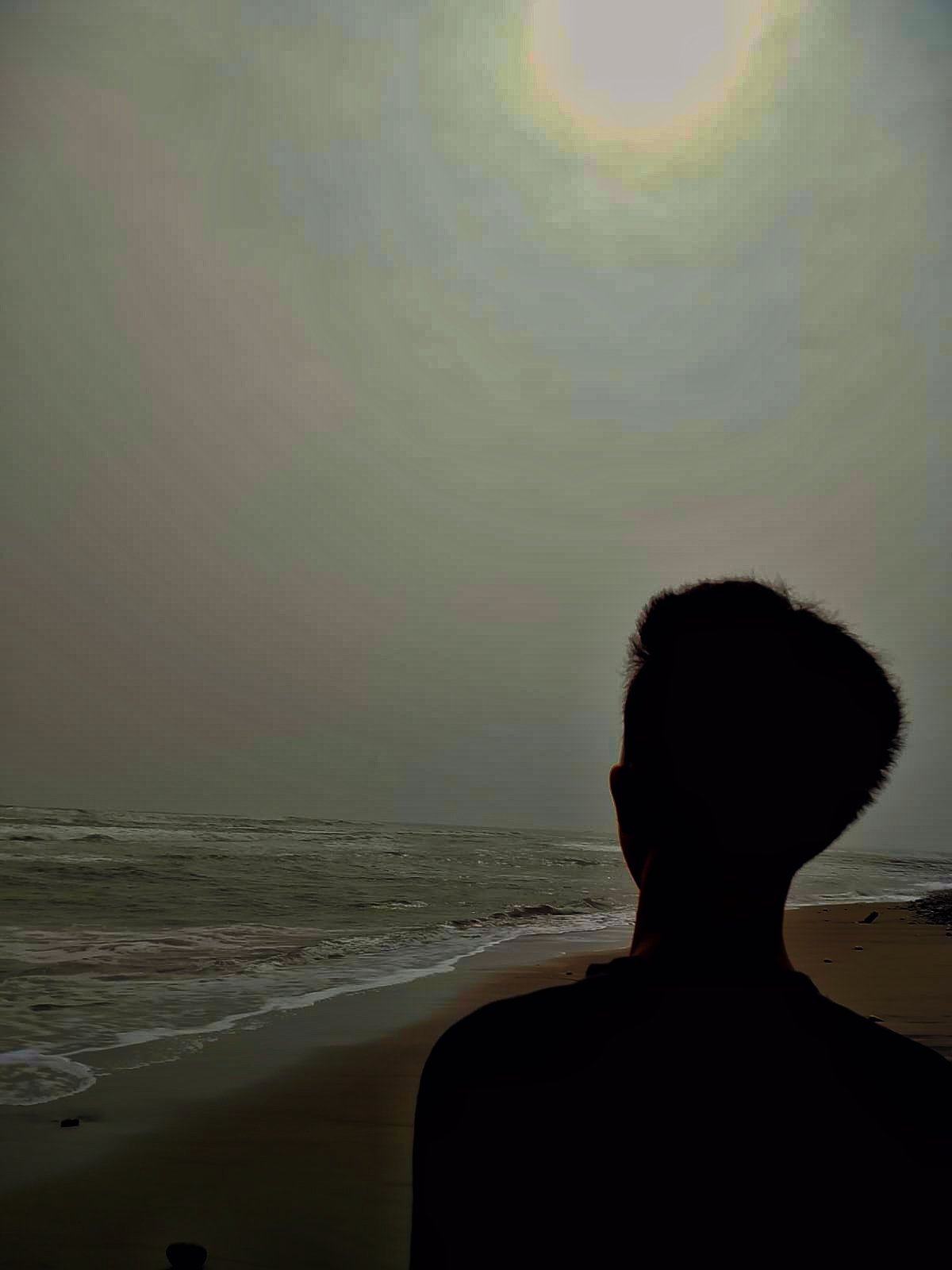 M. Syafiiq berdiri menghadap laut di pantai Bengkulu saat senja